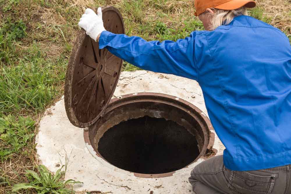 working plumber opens a sewer septic Riverside, CA